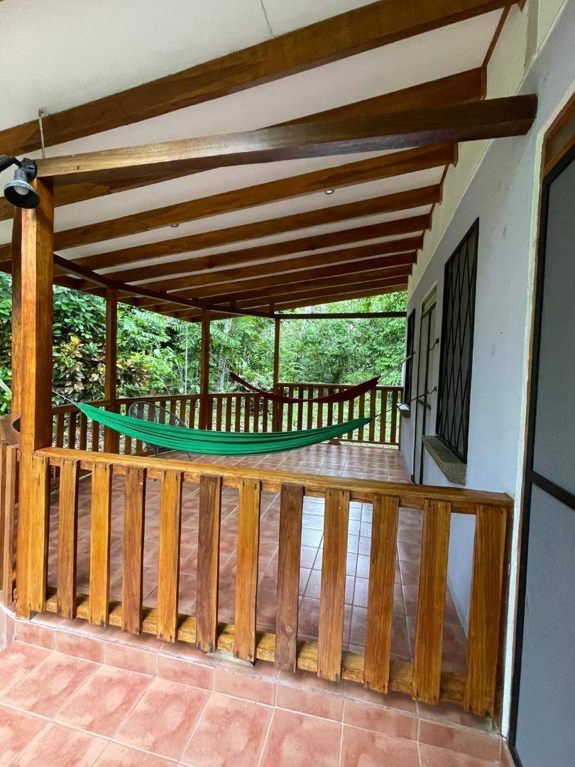 Wooden porch with hammocks facing the greenery